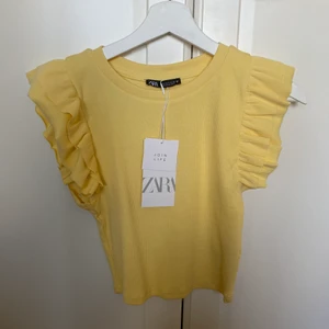 Topp från zara - Gul topp från zara. Helt oanvänd med prislappen kvar. Om du har frågor eller funderingar, om tex frakt, skriv innan du lägger bud. Lägg inte bud om du inte har bestämt dig för att köpa! 🤗