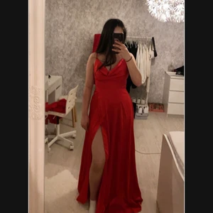 Röd silkes bal/fest klänning med slits - En röd silkes klänning med öppen rygg som har slits. Klänningen är i storlek xs men den passar väldigt bra för de som bär S också.  Den är helt oanvänd och köpt i Spanien. PRIS GÅR ATT DISKUTERA VID SNABB AFFÄR!