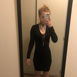 Svart kort klänning - Super fin svart kort klänning med snörning fram till. Den är använd en gång på ett nyår och är från Gina. Storlek xs men passar perfekt som S också. 