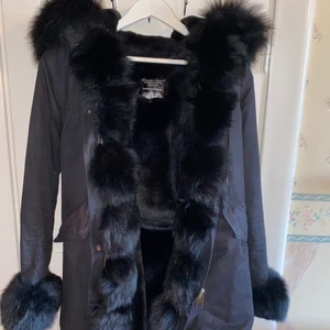Svart parkasjacka  - I använt skick. Päls inuti jackan förutom i armarna 