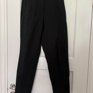 Svarta kostymbyxor storlek xs - Svarta kostymbyxor som passar perfekt till vardags och till finare tillfällen. Högmidjade. Oanväda 