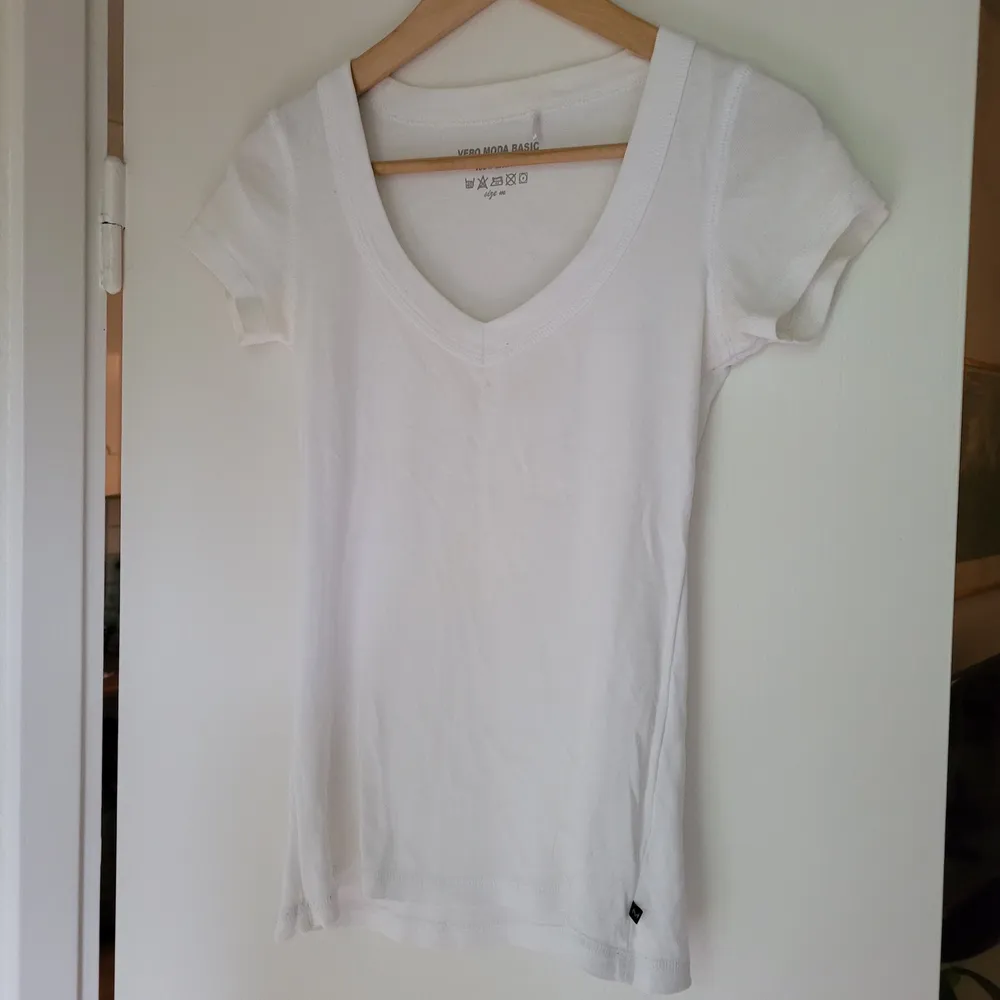 En vanlig,  Snygg v-ringad vit Tshirt. Vero Moda stl.M. Bomull.  Använd ett fåtal gånger. Fraktkostnad tillkommer.. T-shirts.