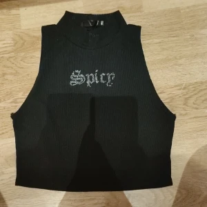 Linne  - Ett snyggt linne med text där det står spicy på,  som jag fick av min syster men har aldrig använt, säljer för vilket pris som helt över 20 kr