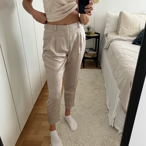 Kostymbyxor i satin  - Fina byxor i satin. Provisoriskt upplagda i benen och kan sys ordentligt om man vill. Höga i midjan.