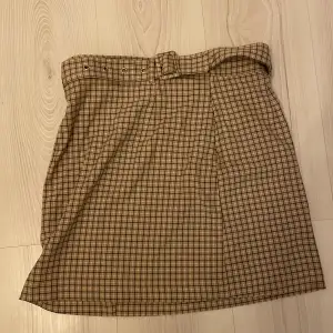 Rutig kjol med bälte, a linjeformad och ger clueless-vibes😎