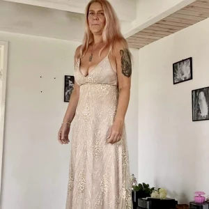 Festklänning st 10 eller S - Klänning för fest, student eller avslutning Fint bling med fin fallande tyg. Endast provad ej använd. Färg beige. 