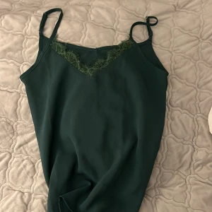 Linne - Ett mörk grönt fint linne med spets i storleken XS🤗