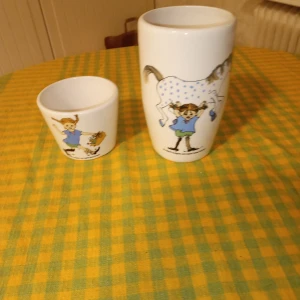 Pippi mugg och pippi kopp. - Fint set pippi mugg 13 cm hög  och pippi kopp 6 cm hög.med motiv av pippi .fint skick .hämtas i Skene alt skickas o köpare betalar frakten o Swishbetalning tillämpas alt kontant betalning .