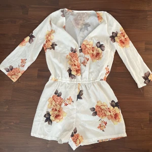 Superfin sommarjumpsuit - En fin jumpsuit med blommor på.  Knappt använd.  Storlek S