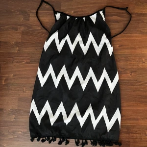 Svartvit strandklänning - Superfin strandklänning med tofsar nedtill. Aldrig använd. 