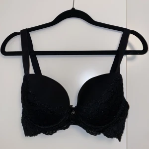 Svart Spetsbh - Svart spets bh från Cubus med lätt push up och bygel. Knappt använd och väldigt bra skick. Storlek 65E men funkar för någon med 70D också.