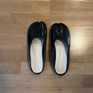Tabi slip-ons  - Tabi slip-ons i strl 40. Använda ett fåtal gånger. Bra skick! Tabi är en traditionell japansk sko som anses vara bra för balansen och motverkar missformad stortå.