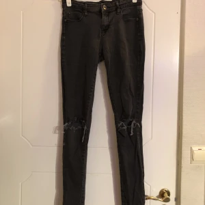 Håliga jeans - mörkgråa jeans köpta på Lindex. de är väl använda och lätt solblekta, men i bra skick, har bra passform och är jättesköna 👍🏻 skicka pm om du har frågor eller vill se fler bilder <3 (hålen på knäna är klippta av mig)