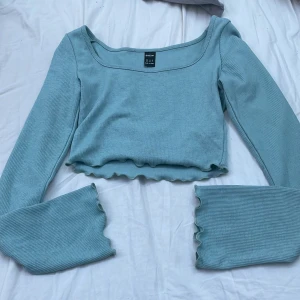 Långärmad crop topp - Blå långärmad croptop med vågiga ändar. Oanvänd pga att den är för liten. Från SHEIN. Storlek xs. Original pris 100kr. 