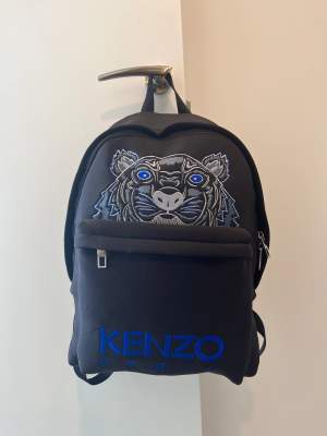 Säljer denna Kenzo ryggsäck i ”våtdräkts material”. Ryggan köptes i Paris för några år sedan men endast använd ett handfull antal gånger så den är i närmaste nyskick.