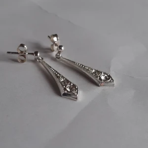 Silver örhängen  - Örhängen i äkta silver med 3 stenar i. Lite triangelformade och superfina. 2,5 cm lång och 0,5 cm bred. Helt oanvända.