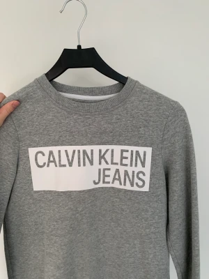 Calvin Klein tröja  - Grå Calvin Klein sweatshirt. Köpt i usa och fortfarande fint skick. Storleken är xs men den är stor i storleken och passar s och möjligtvis m 