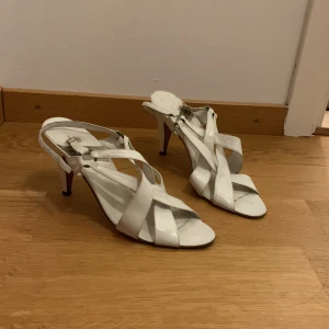 Vita klackskor - Vita läder klackskor,  10cm klack men känns inte så högt att gå i. 