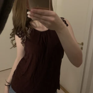 Topp med spets  - Vinröd topp från h&m i storlek l, men jag skulle säga att den passar xs/s, linnet har spets på bägge armarna 