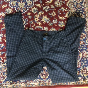 Rutiga byxor  - Byxor köpta secondhand. Bra skick. Midja mätt liggandes 39 cm samt Innerbenslängd 84 cm.