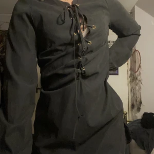 Klänning - Klänning i strl S/M med snörning. Guld detaljer. Sammets liknande material på utsidan. Säljer då den tyvärr är för stor för mig