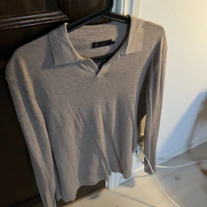 Långärmad pikétröja  - Långärmad stickad pikétröja från Riley med öppen krage perfekt till sommaren. Väldigt sparsamt använd så i mycket bra skick, tyvärr vuxit ur. Köpt för 899:- mitt pris 399:-