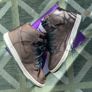 Nike dunk high baroque brown ”beef and broccoli” - 🥩🥦 Nike dunk high baroque brown / beef and broccoli som de också kallas. Båda skosnören finns ( 🟢&🟤).  Väldigt försiktigt använda men med några slitage, lite starloss och skrapmärke (Be om bilder) Kan mötas upp / skickas mot fraktkostnad eller rocker. 