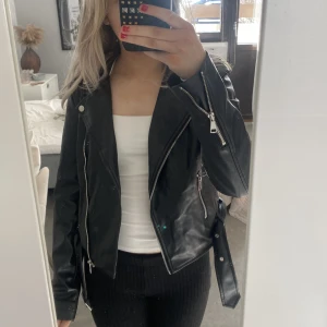 Skinnjacka  - Säljer nu min skinnjacka ifrån Nelly, som tyvärr har blivit förliten. Har silverdetaljer och är i bra skick🥰🥰