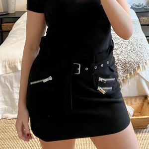 Svart kjol i mockaimitation - Svart kjol i mockaimitation och silvriga detaljer samt bälte