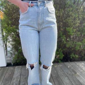 Ljusblåa jeans från Gina tricot med håll vid knäna. Aldrig använda, storlek 36