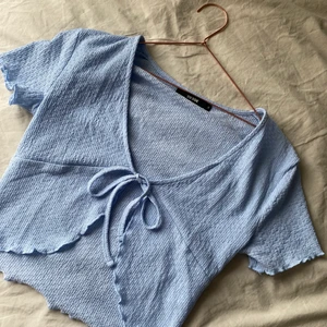 Blå topp med knytdetalj - Topp från BIKBOK i väldigt bra skick som aldrig är använd. Säljer för 50kr 