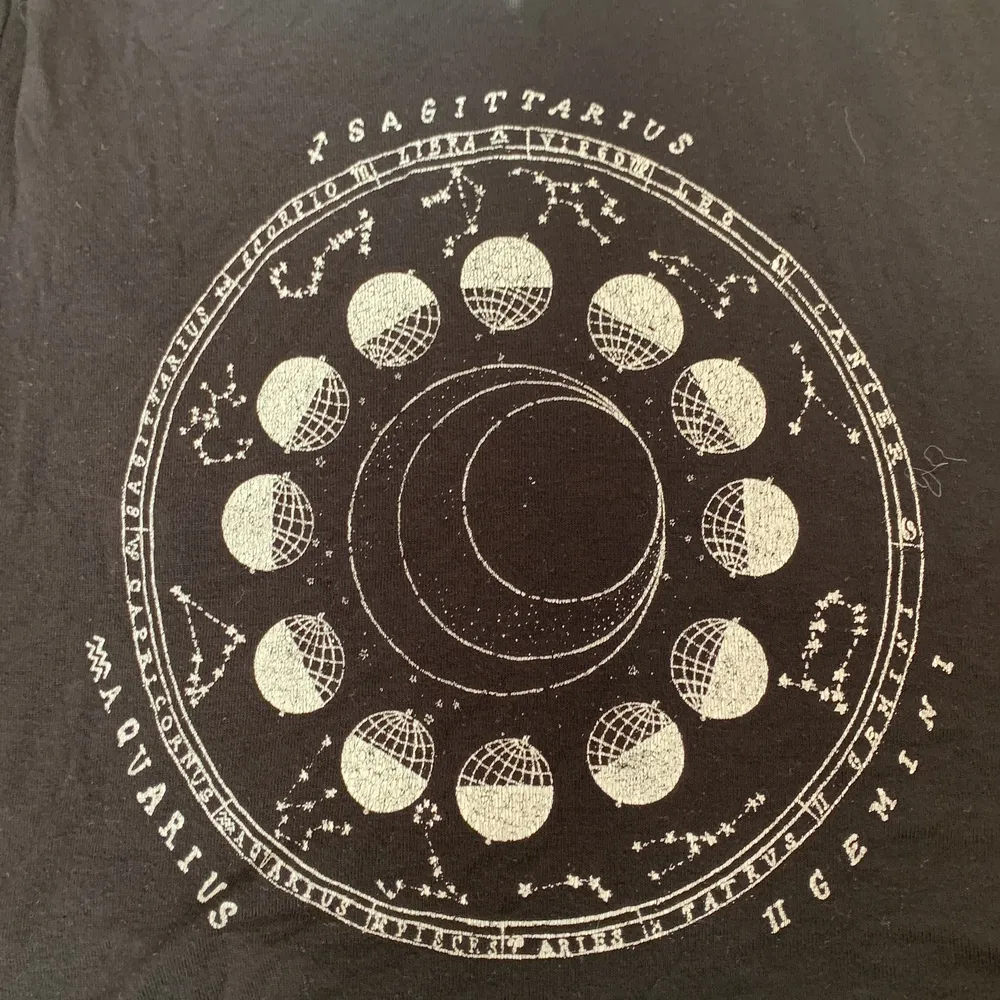 Stjärntecken t-shirt. Står alla 12 stjärntecken runt i cirkeln, och utanför cirkeln står det i lite större text Sagittarius (skytten), Aquarius (Vattumannen) och Gemini (tvillingarna). Vet inte var den är köpt, skulle gissa på hm och storleken vet jag inte heller men den är som en xs/s. T-shirts.