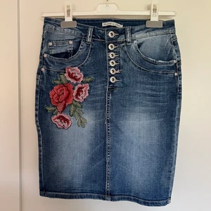 Jeanskjol med brodyr  - Blå jeanskjol med brodyr, vintage style, från Palce du Jour. Storlek 34, helt oanvänd.  