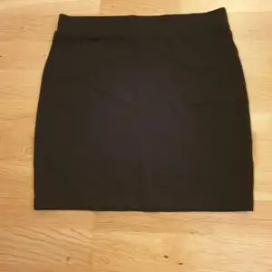 Svart stretchig kjol från Åhléns stl M.                             Midjan ca 79 cm, längden ca 45cm 