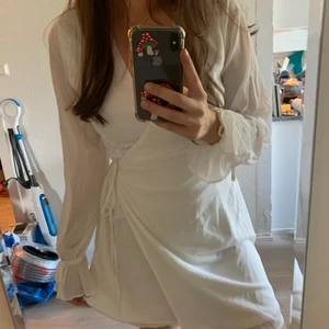 Vit klänning NA-KD  - Vit sommar klänning i topp skick, oanvänd med prislappkvar. Storlek 38 med Justerbar passform i midjan (omlott klänning) inte genomskinlig.                                      klänningen finns även i storlek 40 också helt oanvänd ord prislappkvar! Skriv gärna vid frågor och om pris!✨