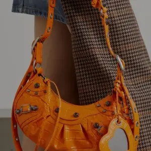 Orange väska dragkedja plånbok som hänger fast likaså spegel. Den har många vackra detaljer i handtaget har en svart och använder bara den. Den som köper väskan för förtur till köp av prada size 37-38 nypris 32 000 på dem.