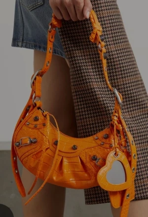 Balenciaga Cagoles - Orange väska dragkedja plånbok som hänger fast likaså spegel. Den har många vackra detaljer i handtaget har en svart och använder bara den. Den som köper väskan för förtur till köp av prada size 37-38 nypris 32 000 på dem.