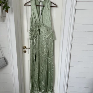 Grön maxiklänning - Säljer nu denna jättevackra salviagröna maxiklänningen med öppen rygg från Topshop. Har även snören vid midjan för att ljustera passformen! Säljs i sin orginalpaketering och är oanvänd. Orginalpriset är 1019kr men säljer för 400kr inklusive frakt!💘 