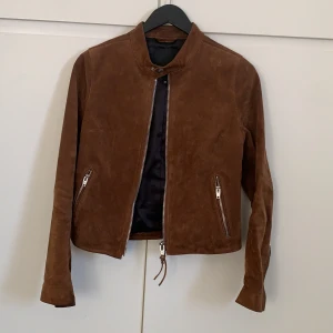 Mocka jacka  - Säljer denna snygga vårjacka från Rockandblue i äkta mocka. Stl 38. Nyskick, helt utan slitage eller fläckar. Säljer pga att den är för liten annars hade jag så gärna behållt den. 
