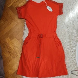 Klänning - Helt ny klänning i fina korall färg. Strl xs men passar som s också.