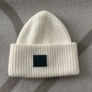 Acne mössa  - En benvit Acne mössa med svart märke. Knappt använd. 