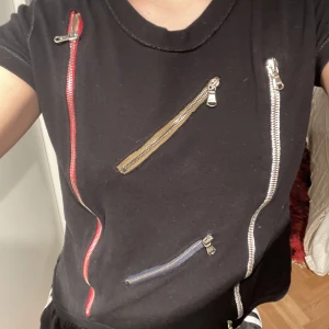 DOLCE & GABBANA TOPP - Vintage DOLCE & GABBANA t-shirt med olika dragkedjor som går att öppna över båda framsida och baksida. Står ingen storlek men gissar i storlek S/M. Super bra skick. Köpt för 300 kr. Knappt använd 