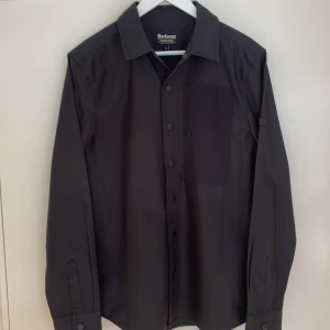 Barbour International overshirt - Barbour overshirt. Lätt bomull med lite vaxig känsla. Stor bröstficka på vänster sida. Svart, storlek M. Oanvänd. 