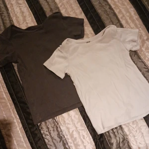2 t-shirtar barn - 1 vit i storlek 80, 1 mörk blå/grå i storlek 80, inköpt från H&M, nyskick 