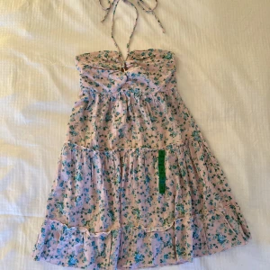 Halterneck sommarklänning - Sommarklänning från Stradivarius. Säljer pga för liten. Ej använd (lappar sitter kvar). Storlek 36, men känns mer som 34. För referens: jag har vanligen 36/38 men den satt lite för tajt på mig.