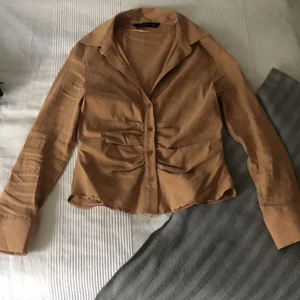 Linneskjorta - En beige aktig skjorta i linne med tightare passform. Använd en gång och säljer då jag har en nästan likadan. Kan mötas upp i Sollentuna annars så står köparen för frakt!💕