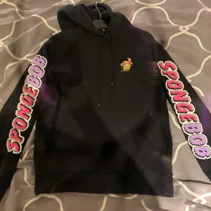 Svart svampbob hoodie - Säljer en cool svampbob hoodie då den är för liten för mig, köpt för länge sen men inte kommit till användning, väldigt cool och schyst tryck på ryggen, storlek m 