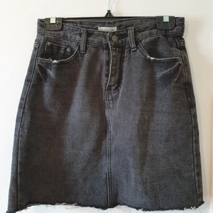 Grå jeanskjol - Grå jeanskjol från Muzicun (?). Fint skick! Rå kant nertill, trasig bakficka. Strl M men skulle säga att den passar 36-38 eller S. Jag har själv 38 och tycker det är precis att den passar mig. Hög midja. Dm för mått. 