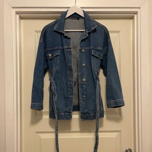 Jeans jacka strl 38 - Jeans jacka med bälte i midjan från boohoo i strl 38. Använd men i bra skick.