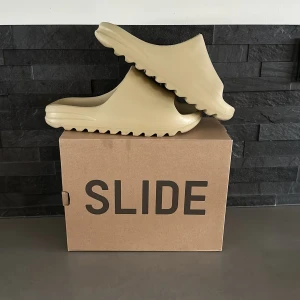 Adidas yeezy slides - Detta är ett par adidas yeezy slide pure. De är använda men väldigt bra skick. Storlek 44,5 och de är små i storlekarna. Jag kommer sälja dessa för 1000 kr men pris kan diskuteras. Skriv för mer bilder och intresse.